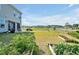 Landscaped backyard featuring green grass, raised garden beds and community views at 121 Canyon Gap Way, Raleigh, NC 27610