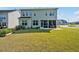 Open backyard with green grass and a covered patio at rear of a 2-story home at 121 Canyon Gap Way, Raleigh, NC 27610