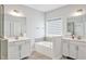 Bright bathroom featuring double vanity, soaking tub, tile flooring and neutral decor at 121 Canyon Gap Way, Raleigh, NC 27610