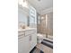 Updated bathroom with white vanity, decorative mirror, gray tile shower, and glass doors at 121 Canyon Gap Way, Raleigh, NC 27610
