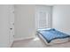 Bright bedroom with neutral walls, a white door, and a large window with natural light at 121 Canyon Gap Way, Raleigh, NC 27610