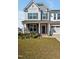Inviting home exterior showcasing a well-kept lawn, stone accents, tasteful landscaping, and a covered front porch at 121 Canyon Gap Way, Raleigh, NC 27610