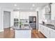 A stunning kitchen showcases stainless steel appliances, a large island, and white cabinetry at 121 Canyon Gap Way, Raleigh, NC 27610
