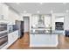 Modern kitchen featuring white cabinets, stainless steel appliances, an island, and hardwood floors at 121 Canyon Gap Way, Raleigh, NC 27610
