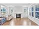 Bright living room showcasing hardwood floors, a cozy fireplace, and large windows with scenic backyard views at 121 Canyon Gap Way, Raleigh, NC 27610
