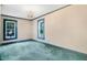The bedroom has two windows, neutral walls and carpets, blue trim, and a chandelier at 125 W Pine St, Pine Level, NC 27568