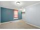 Simple bedroom with blue and gray walls, carpeted floor, and closet rod at 125 W Pine St, Pine Level, NC 27568