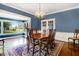 Dining room showcases blue walls, wood table set on rug, chandelier, and large bay window at 125 W Pine St, Pine Level, NC 27568