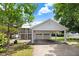 Exterior view of a two-story home with a spacious carport, two-car garage, and ample parking space at 125 W Pine St, Pine Level, NC 27568