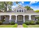 Classic home featuring a covered front porch with elegant columns, manicured lawn, and inviting entryway creating a warm welcome at 125 W Pine St, Pine Level, NC 27568