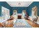 Elegant living room featuring a fireplace, hardwood floors, and stylish chandelier with blue accent wall at 125 W Pine St, Pine Level, NC 27568