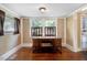 Well-lit home office features hardwood floors, two windows, and a beautiful wooden desk at 125 W Pine St, Pine Level, NC 27568