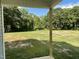 Backyard view, showcasing a green yard with trees, visible from the covered back porch at 175 Oakfield Trace Dr, Four Oaks, NC 27524