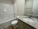 Clean bathroom with granite vanity, laminate floors, and a shower-tub combination at 175 Oakfield Trace Dr, Four Oaks, NC 27524