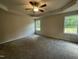 Bright bedroom with neutral walls, carpet, a ceiling fan, and two windows providing ample natural light and outdoor views at 175 Oakfield Trace Dr, Four Oaks, NC 27524