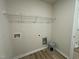 Functional laundry room with laminate flooring, a wire rack shelf, and washer and dryer hookups at 175 Oakfield Trace Dr, Four Oaks, NC 27524