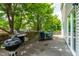 Cozy back patio with grill, table set, and tree shade perfect for outdoor relaxation and entertaining at 2011 Unbridled Dr, Knightdale, NC 27545