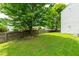 Expansive grassy backyard enclosed by a wooden fence and mature trees, creating a private outdoor space at 2011 Unbridled Dr, Knightdale, NC 27545