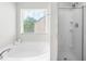 Bright bathroom featuring a soaking tub with a window and a glass-enclosed shower at 2011 Unbridled Dr, Knightdale, NC 27545