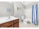 Bathroom with a wood vanity, white sink, and shower/tub combination with a striped curtain at 2011 Unbridled Dr, Knightdale, NC 27545