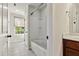 Neutral bathroom with a bathtub and shower combo, tiled floors, and a large window for natural light at 226 Begen St, Morrisville, NC 27560