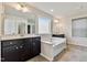 Bathroom featuring a soaking tub, double vanity, tile floors, and neutral decor at 226 Begen St, Morrisville, NC 27560