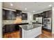 Wide angle of kitchen showcasing granite island, stainless appliances, and dark wood cabinets at 226 Begen St, Morrisville, NC 27560