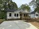 Charming single-story home featuring a welcoming front porch and newly paved driveway, complemented by lush green trees at 2309 Pinecroft Dr, Burlington, NC 27217