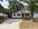 Charming single-story home featuring a welcoming front porch and newly paved driveway surrounded by mature trees at 2309 Pinecroft Dr, Burlington, NC 27217