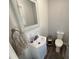 Cozy half bathroom featuring a white vanity, framed mirror, and hardwood style flooring at 2433 Zacks Mill Rd, Angier, NC 27501