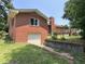 Back exterior view of a charming brick house with a detached garage and a wooden deck, blending classic charm with functionality at 2433 Zacks Mill Rd, Angier, NC 27501