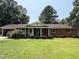 Charming brick ranch with a covered front porch, complemented by mature trees and a well-manicured lawn at 2433 Zacks Mill Rd, Angier, NC 27501