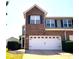 Two-story townhouse with brick facade, a two-car garage, dark shutters, and manicured landscaping at 2452 Bay Harbor Dr, Raleigh, NC 27604