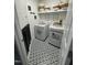 Charming laundry room with black and white patterned floors, white appliances and shelving at 2452 Bay Harbor Dr, Raleigh, NC 27604