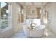 Luxury bathroom featuring a soaking tub, marble walls, and bronze shower fixtures at 249 Mollie Meadow Dr, Zebulon, NC 27597