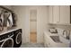 Well-organized laundry room with ample storage, a sink, and modern appliances at 249 Mollie Meadow Dr, Zebulon, NC 27597