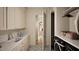 Functional laundry room with white cabinets, a sink, and black front load washer and dryer at 249 Mollie Meadow Dr, Zebulon, NC 27597