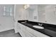 Bathroom featuring a double vanity with a black countertop and white cabinets and shower/toilet combo at 267 Ashley Woods Ct, Clayton, NC 27527