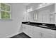 Bathroom featuring a double vanity with a black countertop and white cabinets and a window with blinds at 267 Ashley Woods Ct, Clayton, NC 27527