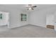 This bedroom features neutral carpet, white walls, ceiling fan, and a window with a view to the outdoors at 267 Ashley Woods Ct, Clayton, NC 27527