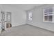 This bedroom features neutral carpet, white walls, and two windows with blinds at 267 Ashley Woods Ct, Clayton, NC 27527