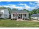 Inviting single-story home with a quaint front porch, rocking chairs, and manicured front lawn at 267 Ashley Woods Ct, Clayton, NC 27527