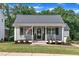 Charming home featuring a welcoming front porch, American flag, and beautifully landscaped lawn at 267 Ashley Woods Ct, Clayton, NC 27527