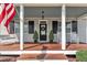 Charming front porch featuring rocking chairs, an American flag, and a stylish front door with wreath at 267 Ashley Woods Ct, Clayton, NC 27527