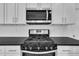 Close up of stainless steel stove, granite countertop, and white cabinetry at 267 Ashley Woods Ct, Clayton, NC 27527