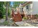 Exterior home view of wood stairs, brick foundation, and lush landscaping at 3020 Woods Walk Way, Rocky Mount, NC 27804