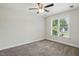Neutral bedroom with ceiling fan, plush carpet and a large window overlooking the outdoor scenery at 3020 Woods Walk Way, Rocky Mount, NC 27804