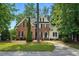 Charming two-story brick home with a manicured lawn, mature trees, and a welcoming front entrance at 3020 Woods Walk Way, Rocky Mount, NC 27804