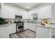 Well-lit kitchen with white cabinets, granite countertops, stainless steel appliances, and wood-look floors at 3020 Woods Walk Way, Rocky Mount, NC 27804