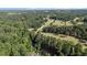 Aerial view showcasing a lush green landscape, golf course, and nearby neighborhood at 3070 Cameron Dr, Henderson, NC 27536